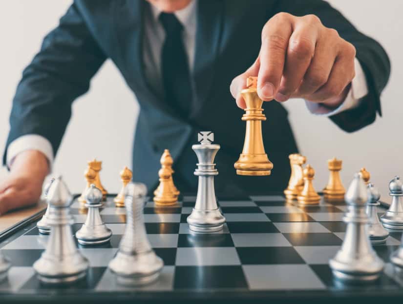 Showing businessperson moving chess piece to symbolise loan structuring strategy